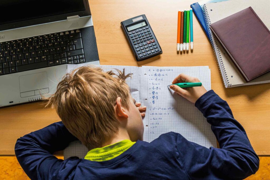 A child avoiding homework, looking frustrated, with his notebook closed. I need a tutor for my child ? 