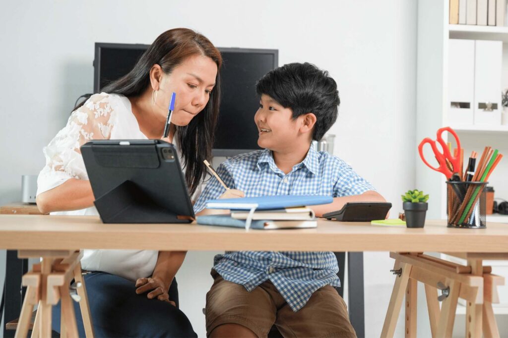 A mother reviewing a tutor's resume with her son, wondering, I need a tutor for my child ?